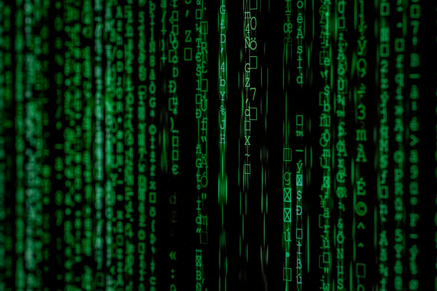 Green code streams descend on a black digital background.